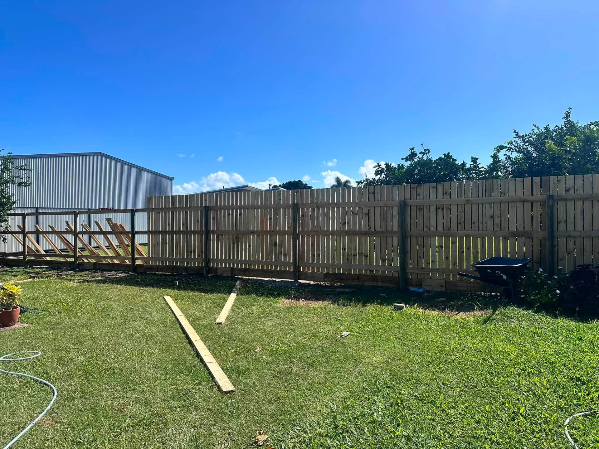 Long run of new timber paling fencing along a grassy Mackay backyard